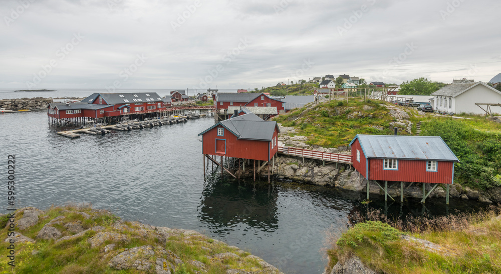 Charming fishing village A I Lofoten (  Å i Lofoten ) in Moskenesøya, with beautiful wooden red houses, small boats and surrounding mountains during summer on Lofoten islands, Norway.