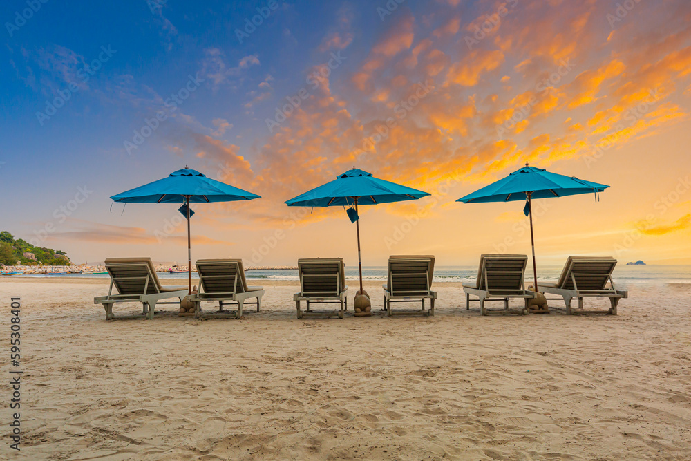 Beaches and sun tables in Thailand,Row of empty sun loungers and orange parasols on the tropical beach at sunset. Vacation in the all inclusive hotel on the Caribbean sea Beaches and sun tables in Thailand,Row of empty sun loungers and orange parasols on the tropical beach at sunset. Vacation in the all inclusive hotel on the Caribbean sea