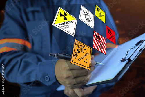 Fotografiet Security officers hold clipboards and inspect the storage of dangerous goods in the warehouse for operator safety such as explosions, radioactive, toxic gases, etc