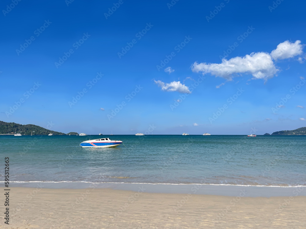 Panorama, seascape, boat on the sea. Clear blue sky and white clouds. Clean white sand. Transparent turquoise water. Sea bay. Tropical beach. Phuket island. Thailand. Summer paradise. Calm Andaman sea