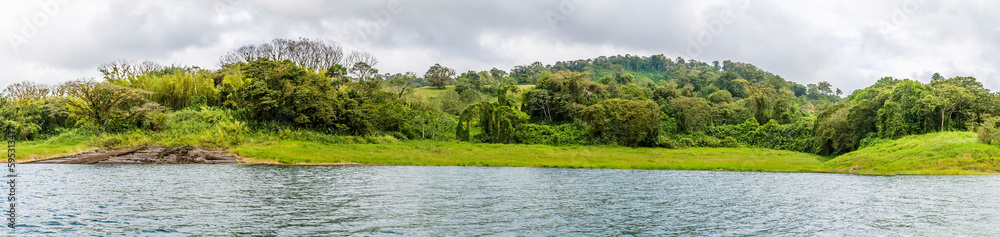 A panorama view across a cove on the shoreline of the Arenal Lake in Costa Rica during the dry season A panorama view across a cove on the shoreline of the Arenal Lake in Costa Rica during the dry season