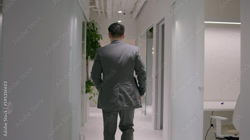 Back view unknown businessman entrepreneur ceo employer hurry run on business meeting with partners in office busy man go in company hallway checking hour on wristwatch late time management lateness