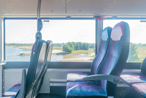 Side view of Empty seats at a european bus driving next to A river in a Dutch polder landscape