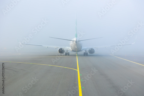 Принти на полотні Airplane taxing on taxiway in white fog conditions