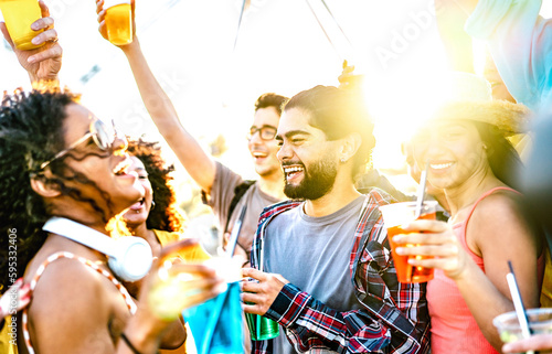 Trendy vacationers dancing at sunset concert on summer days - Fancy life style concept with guys and girls having genuine fun together at spring break party - Bright vivid filter with sunlight halo