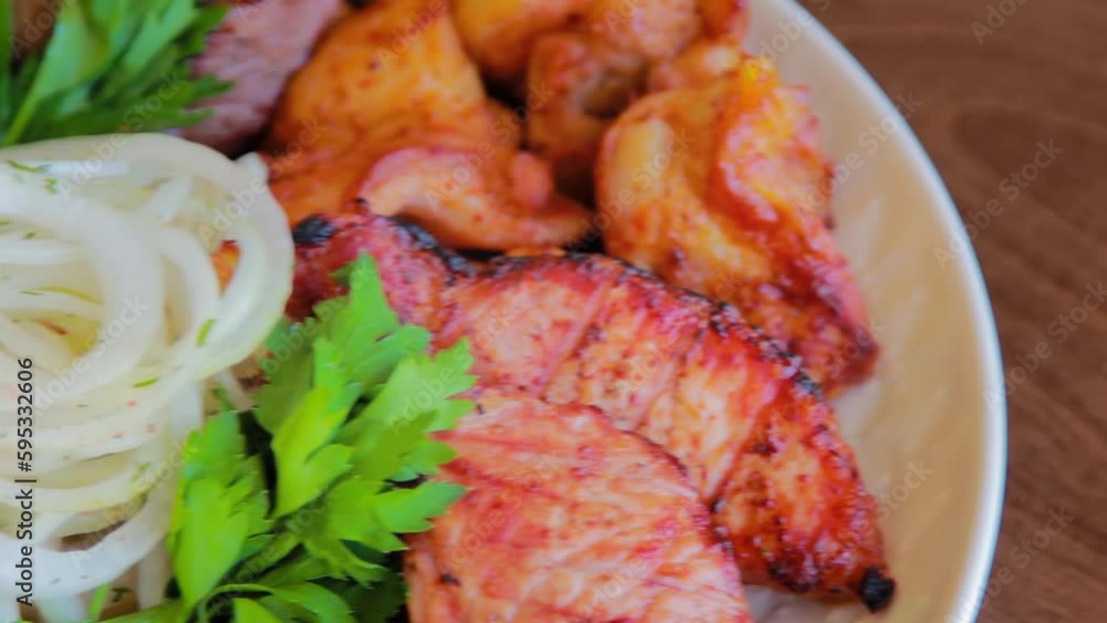 Close-up of an assortment of grilled meats, smooth camera movement, selective focus. Close-up of an assortment of grilled meats, smooth camera movement, selective focus.