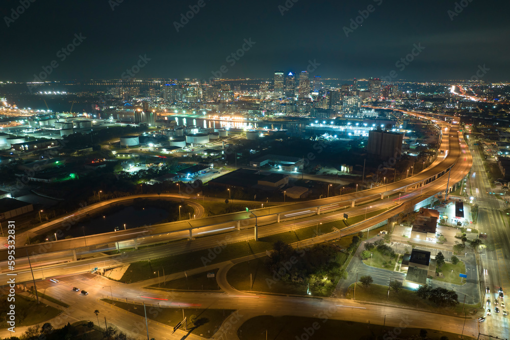 Aerial view of american freeway intersection at night with fast driving cars and trucks in Tampa, Florida. View from above of USA transportation infrastructure