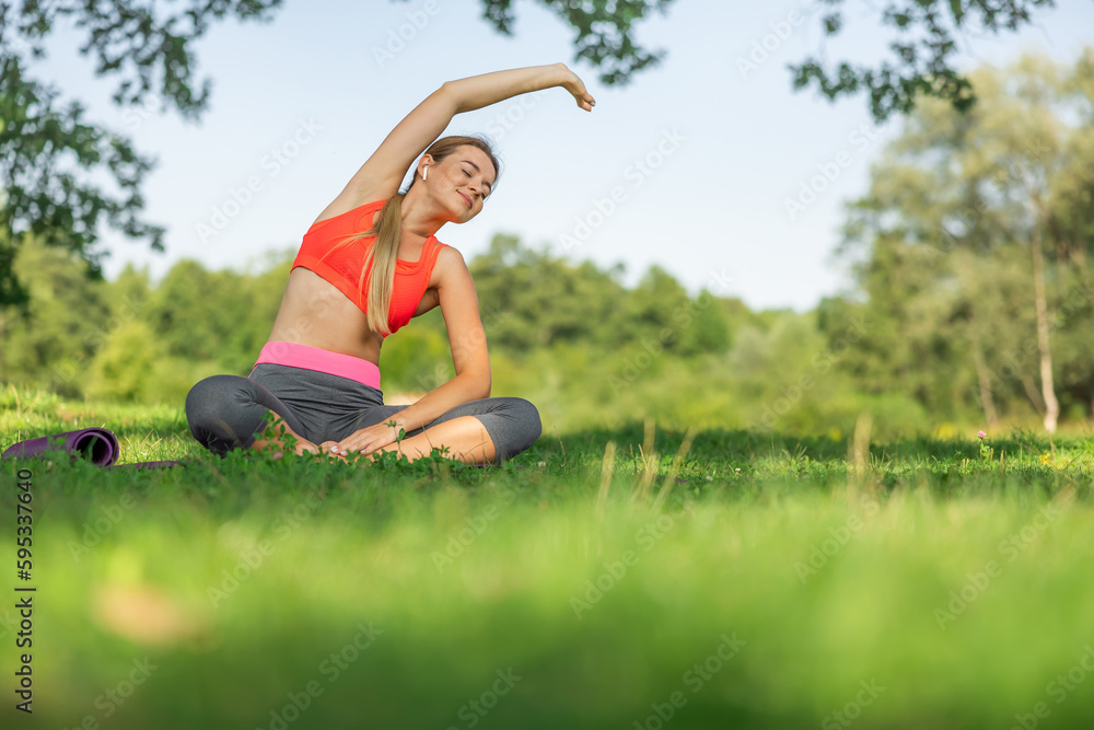 Photo of smiling young sports woman in park outdoors make sport stretching exercises. Photo of smiling young sports woman in park outdoors make sport stretching exercises.