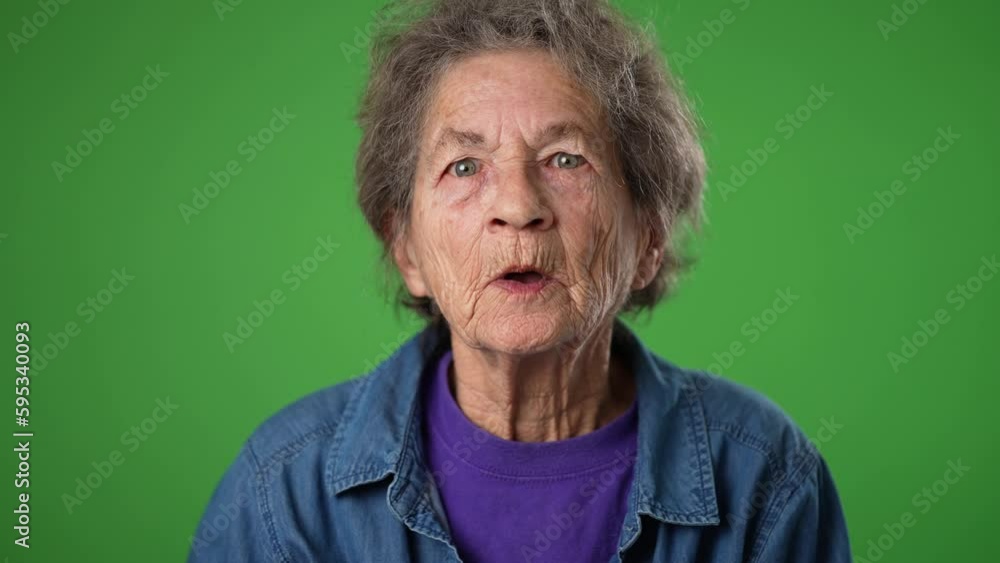 Closeup slow motion funny toothless portrait of elderly senior old woman with wrinkled skin and grey hair has great success winner isolated green screen background in studio. People emotions concept Closeup slow motion funny toothless portrait of elderly senior old woman with wrinkled skin and grey hair has great success winner isolated green screen background in studio. People emotions concept