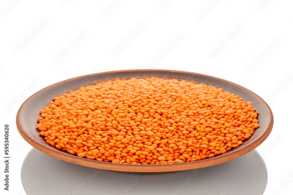 Red lentils on a clay dish, macro, isolated on a white background. Red lentils on a clay dish, macro, isolated on a white background.
