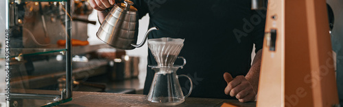 Hand drip coffee, Barista pouring water on coffee ground with filter in cafe photo