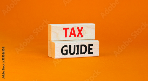 Tax guide symbol. Concept words Tax guide on beautiful wooden block. Beautiful orange table orange background. Business and Tax guide concept. Copy space.