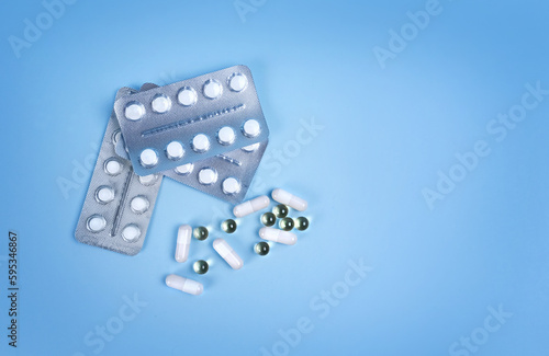 The concept of medicine. A set of pills. a set of medicines. Various capsules. on a blue background, the concept of pills, buying medicines and shopping.