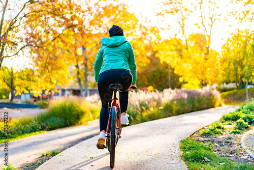 Woman riding bicycle in city park  © Jacek Chabraszewski
