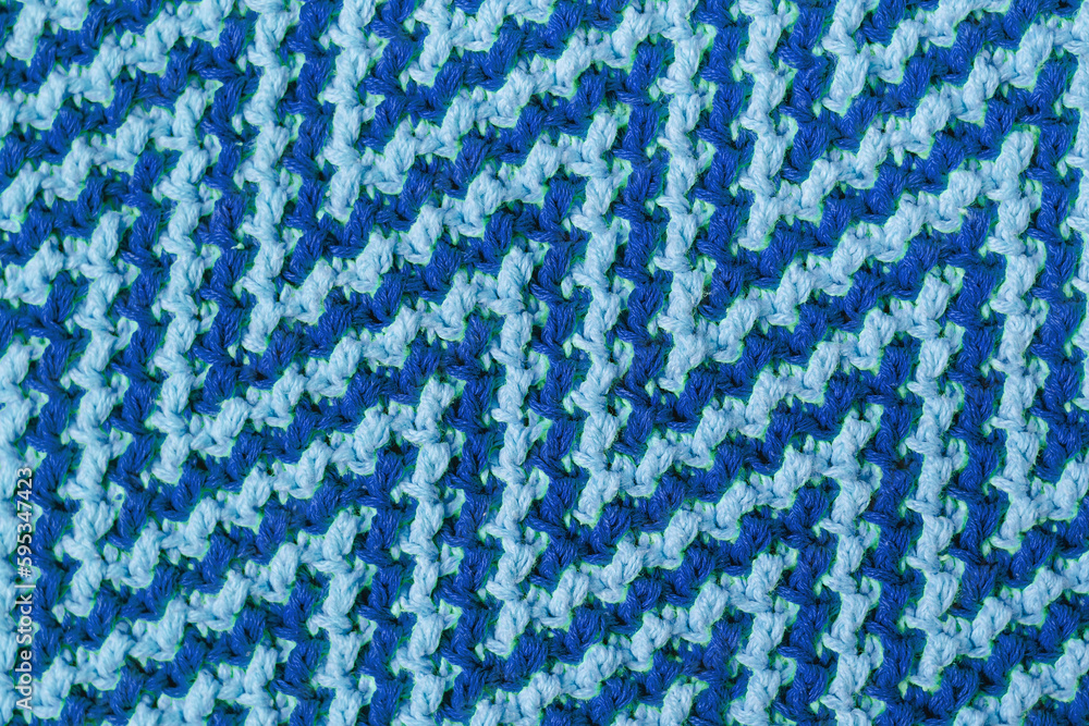 Knitted texture with zigzag pattern. Texture of mosaic fabric with blue geometric ethnic pattern. Crochet mosaic pattern. Knitted texture with zigzag pattern. Texture of mosaic fabric with blue geometric ethnic pattern. Crochet mosaic pattern.