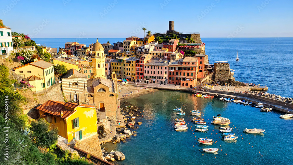 Cinque Terre village of Vernazza, Italy. Aerial view of the harbor with boats in the blue sea.