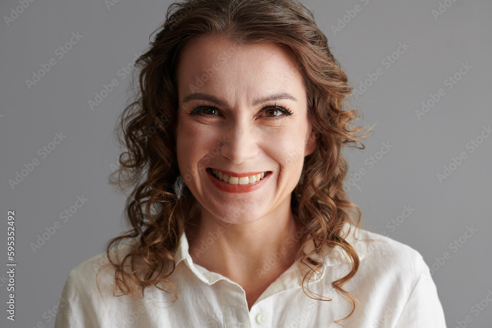Face of happy mature woman with curly hair looking at camera Face of happy mature woman with curly hair looking at camera