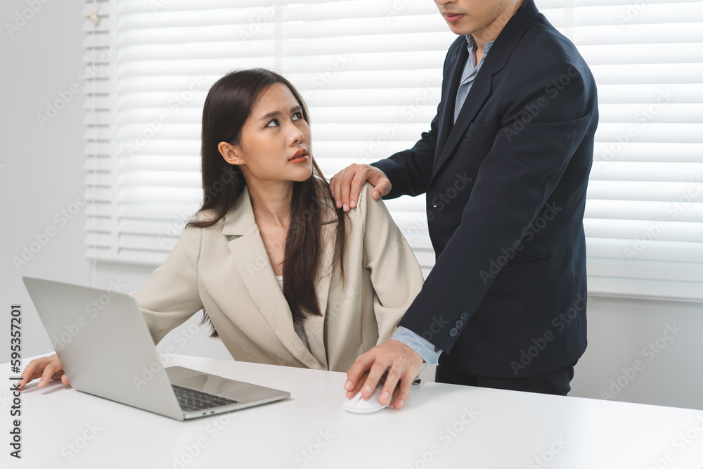 Sexsual harassment in workplace. Unhappy female employee looking at hand of boss touch at her shoulder and feeling disgusted. Sexsual harassment in workplace. Unhappy female employee looking at hand of boss touch at her shoulder and feeling disgusted.