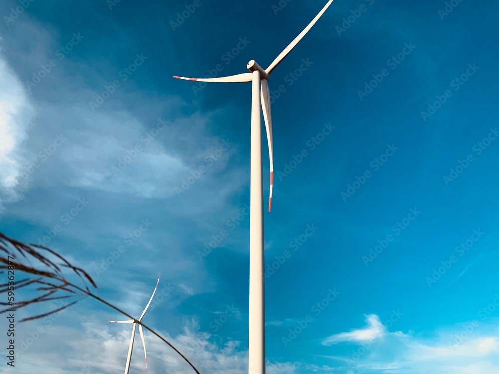 Fototapeta premium A wind turbine in a field with the sky in the background