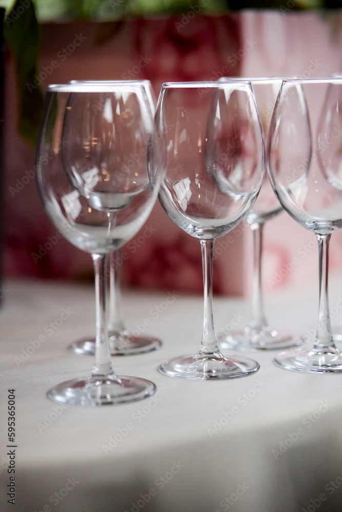 empty wine glasses on the table. empty glasses in a restaurant. empty wine glasses on a table in a restaurant, soft focus, blurred background. vertical photo orientation empty wine glasses on the table. empty glasses in a restaurant. empty wine glasses on a table in a restaurant, soft focus, blurred background. vertical photo orientation