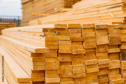 Wooden boards are stored outdoors. Wooden boards  lumber  industrial wood  timber. Pine wood timber stack of natural rough wooden boards on building site.