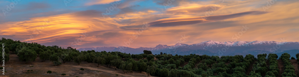 Spectacular lenticular clouds over the snowy peaks of the Sierra Nevada (Granada, Spain) at sunset