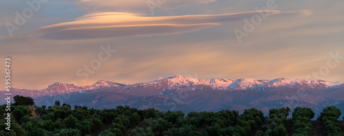 Spectacular lenticular clouds over the snowy peaks of the Sierra Nevada (Granada, Spain) at sunset photo