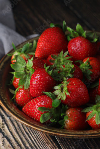 A bowl with ripe bright strawberry in rustic style