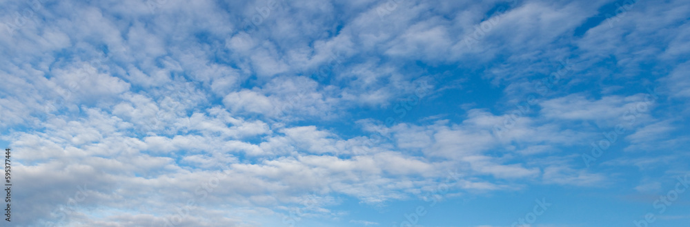 Naklejka premium Blue sky with small white cumulus clouds, copy space