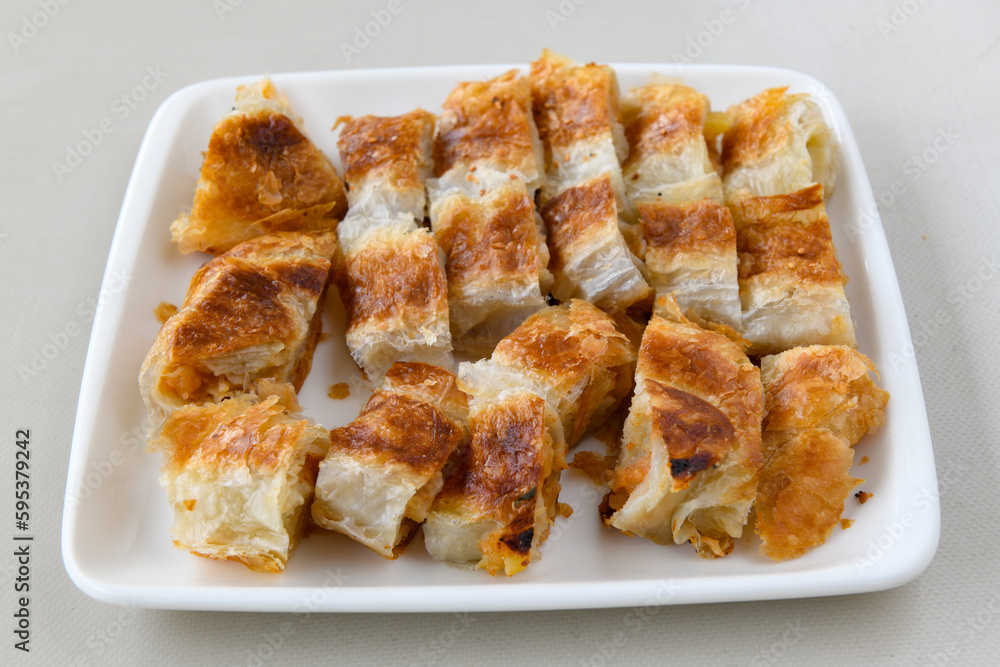 Turkish style meat stuffed filo dough borek served kol boregi. Cheese and minced pie are sliced on a marble background. Turkish name: Kol Boregi, ispanakli, kiymali, Su Boregi Turkish style meat stuffed filo dough borek served kol boregi. Cheese and minced pie are sliced on a marble background. Turkish name: Kol Boregi, ispanakli, kiymali, Su Boregi