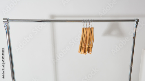 rail for clothes with wooden empty hangers on a white background. panoramic banner