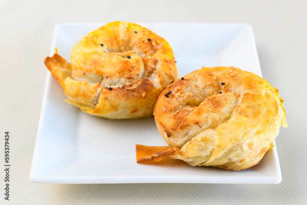 Turkish style meat stuffed filo dough borek served kol boregi. Cheese and minced pie are sliced on a marble background. Turkish name: Kol Boregi, ispanakli, kiymali, Su Boregi Turkish style meat stuffed filo dough borek served kol boregi. Cheese and minced pie are sliced on a marble background. Turkish name: Kol Boregi, ispanakli, kiymali, Su Boregi