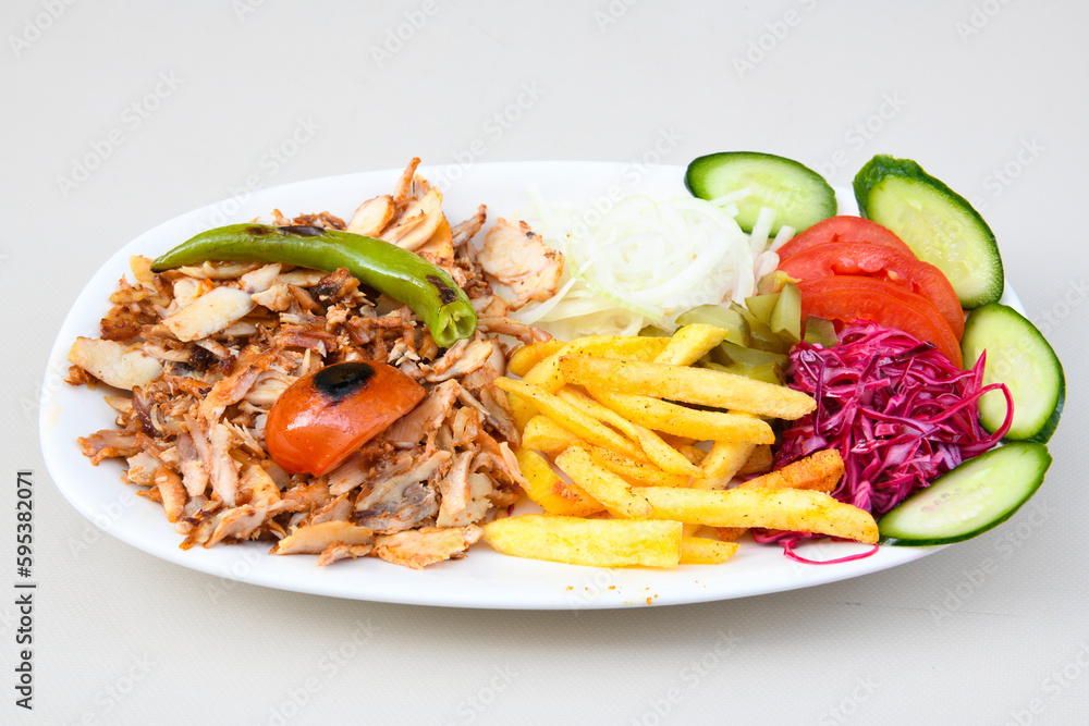 Turkish and Arabic Traditional Ramadan doner kebab with tasty tomato sauce and rice or turkish pilav in white plate on wood table background. ( Pilav ustu doner) Turkish and Arabic Traditional Ramadan doner kebab with tasty tomato sauce and rice or turkish pilav in white plate on wood table background. ( Pilav ustu doner)