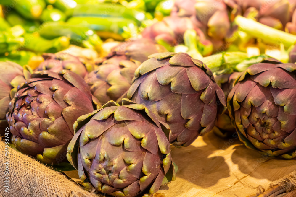 Obraz premium Fresh violet artichoke flower plant on the counter of the store or grocery.