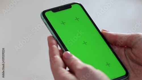 Girl scrolling phone green screen browsing social media chroma key reading news close up hands
