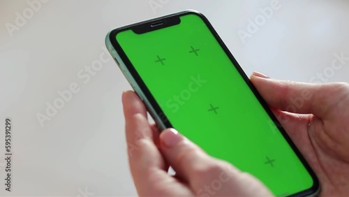 Girl scrolling phone green screen browsing social media chroma key reading news close up hands
