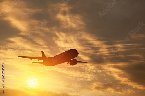 Airplane taking off at the sunset sky.
