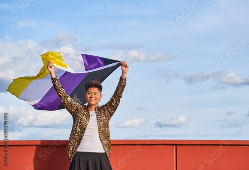 Konstfotografi gender non binary asian person smiling holding gender non binary flag with blue