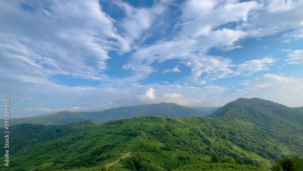 View of mountains with green trees, the Black Sea and the blue cloudy sky in the afternoon - wide angle panning shot. Georgian landscape near Batumi in Georgia. Summer and nature concept View of mountains with green trees, the Black Sea and the blue cloudy sky in the afternoon - wide angle panning shot. Georgian landscape near Batumi in Georgia. Summer and nature concept