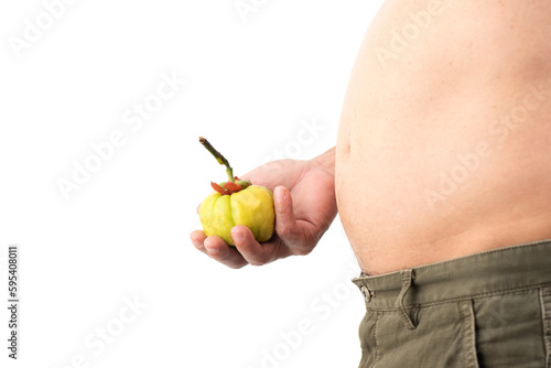 Obese man standing holding garcinia cambogia and has medicinal properties that can help you lose weight. photo