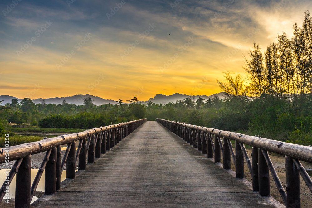 Obraz premium wooden bridge over river sunrise