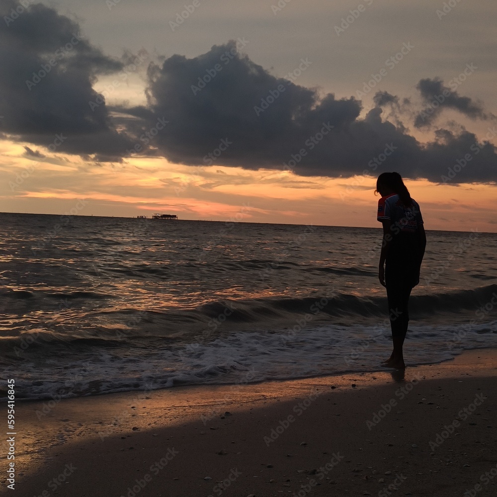 person walking on the beach at sunset sekinchan