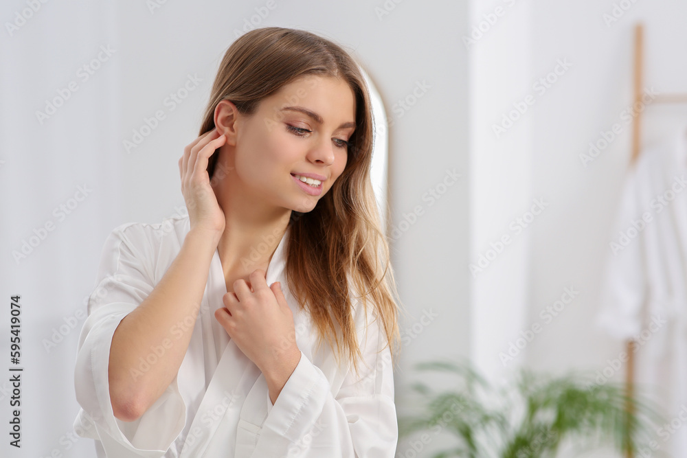 Beautiful happy woman wearing stylish white robe in bathroom. Space for text Beautiful happy woman wearing stylish white robe in bathroom. Space for text