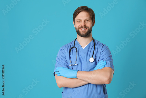 Doctor or medical assistant (male nurse) with stethoscope on turquoise background. Space for text