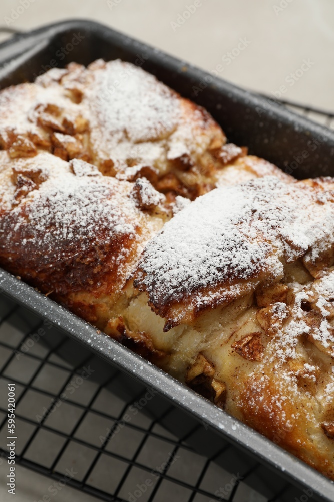 Delicious yeast dough cake in baking pan on table, closeup