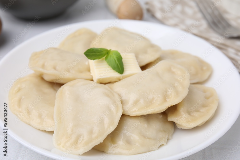 Delicious dumplings (varenyky) with tasty filling and butter on table, closeup