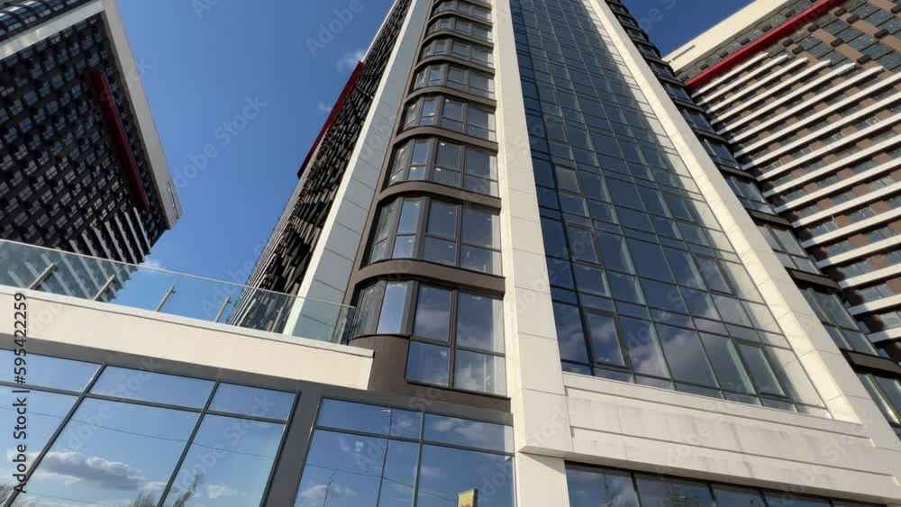 Exterior view of a newly built modern high-rise residential complex with stylobate. Bottom up view. Extreme wide angle shot Exterior view of a newly built modern high-rise residential complex with stylobate. Bottom up view. Extreme wide angle shot