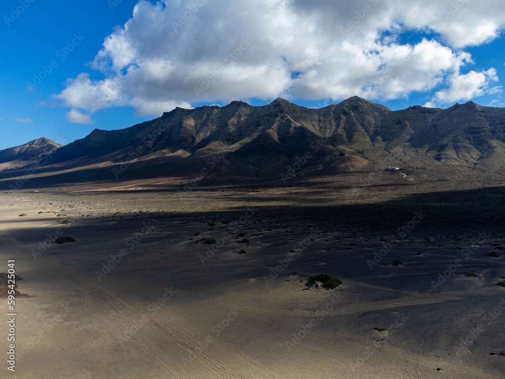 Aerial view on difficult to access golden sandy Cofete beach hidden behind mountain range on Fuerteventura, Canary islands, Spain Aerial view on difficult to access golden sandy Cofete beach hidden behind mountain range on Fuerteventura, Canary islands, Spain