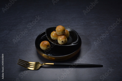 mini bake luxury tart in Japanese hojicha crisp with cranberry pineapple jam paste inside with clove stick and black plate gold fork knife on dark background pastry dessert halal party food menu