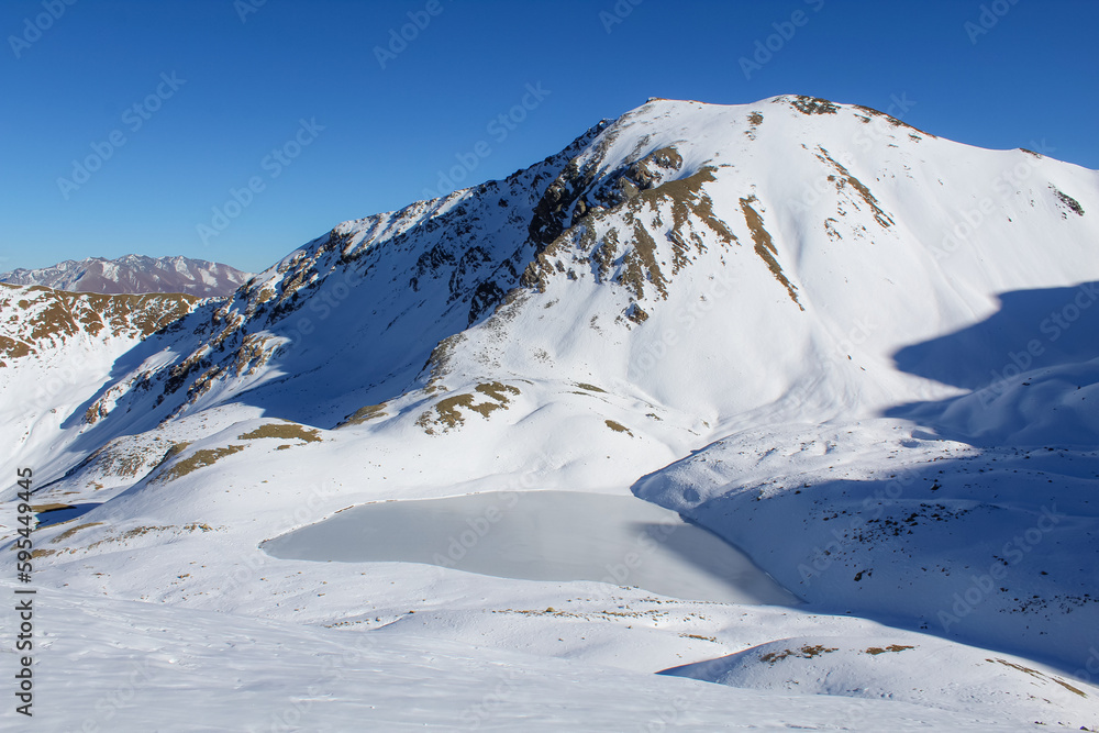 High-mountain Markin Lakes in the Teberda Nature Reserve, winter landscape, blue sky with copy space for text High-mountain Markin Lakes in the Teberda Nature Reserve, winter landscape, blue sky with copy space for text